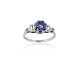 A Sapphire and Diamond Ringthe round cut sapphire in a white claw setting, to baguette cut diamond