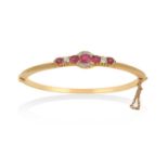 A Ruby and Diamond Hinged Banglethree oval cut rubies flanked by an old cut diamond and a round