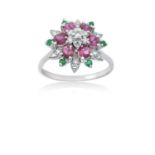 A Ruby, Emerald and Diamond Cluster Ringthe central raised round brilliant cut diamond within a