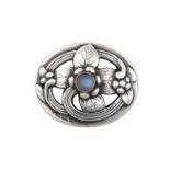 A Brooch, by Georg Jensen depicting stylised foliage within an oval frame, with a round cabochon