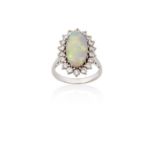 An Opal and Diamond Cluster Ringthe oval cabochon opal within a border of round brilliant cut