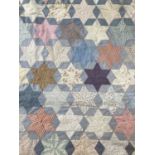 An Early 20th Century Patchwork Cotton Bed Cover, incorporating patchwork of six point stars