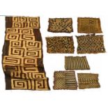 Seven African Kuba Panels, of 'tufted' design in geometric patterns of diamonds and zig zags in