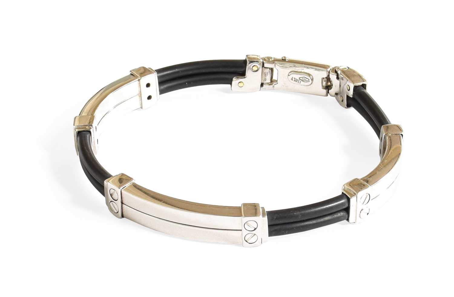 A Contemporary Bracelet, four double row black rubber sections alternate with white plain polished