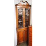 A Sheraton Revival Painted Satinwood Standing Corner Cupboard, with broken swan neck pediment, the