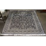 An Unusual Signed Cotton Rug, the indigo field with a one way design of flowering plants enclosed by