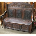 A Carved Oak Box Settle, 18th century elements, decorated with thistles and lunette carving and with