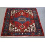 A Hamadan Rug, with a blood red field centered by a sky blue medallion enclosed by compartmentalised