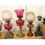 A Victorian Brass Based Oil Lamp, with cranberry font and shade, a similar with cranberry font and a