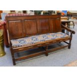 An 18th Century Oak Four Panelled Settle, 183cm by 75cm by 108cmStructurally sound. Some movement in