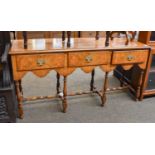 A Figured Walnut Three Drawer Sideboard in William & Mary Style, with shaped apron, turned