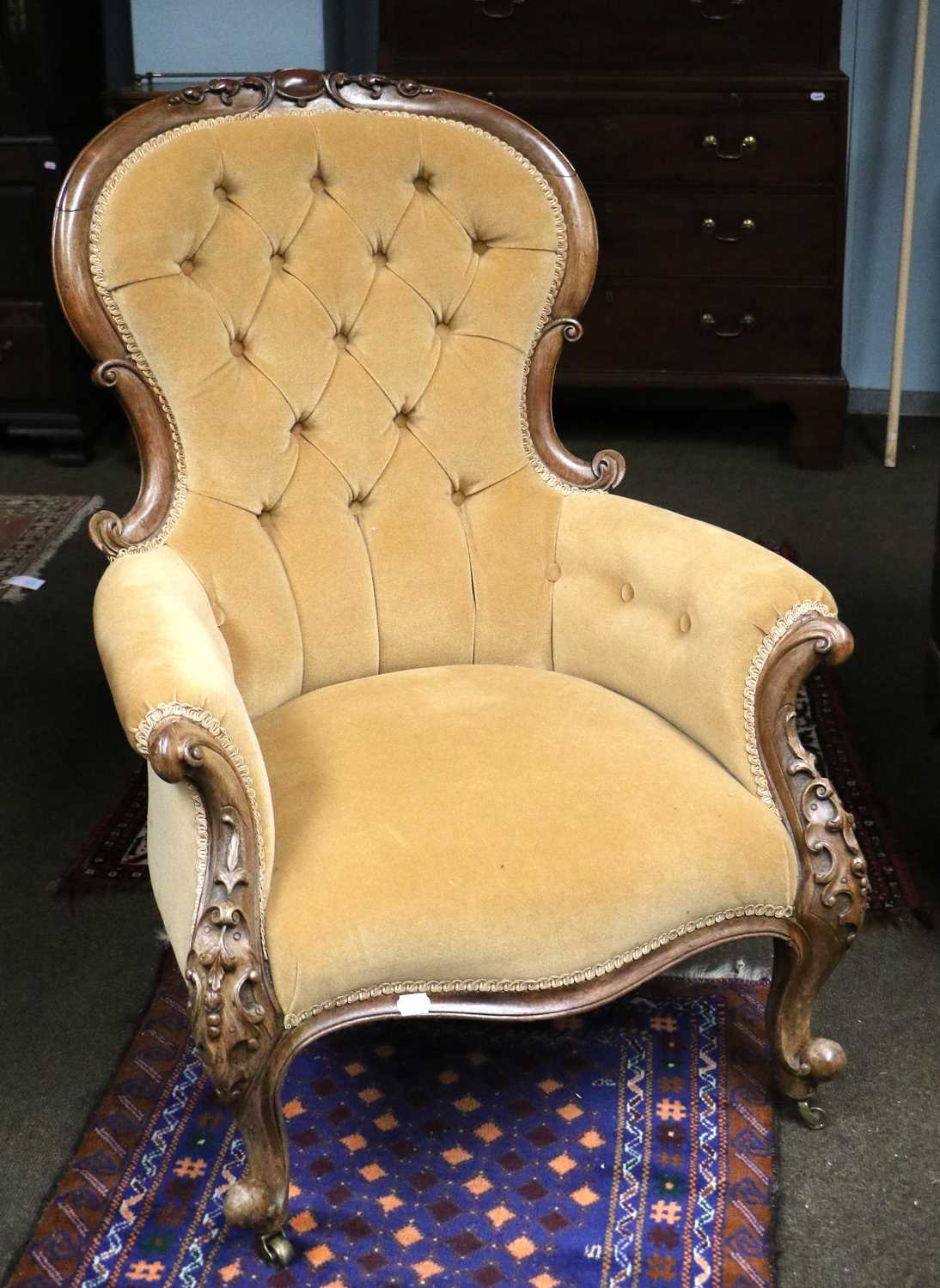 A Victorian Carved Mahogany Framed Spoon Back Armchair, with deep buttoned gold velvet upholstered