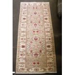 An Agra Design Runner, camel field with a row of flower heads enclosed by meandering vine borders,