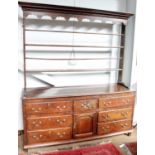 A Mid 18th Century Enclosed Oak Dresser and Rack, the upper section with a Greek Key dentil