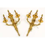 A Pair of Gilt Metal Three-Light Wall Sconces, in Louis XVI style, with leaf-sheathed scroll