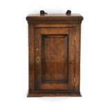 A George III Wall-Mounted Oak Cabinet, late 18th century, the moulded top above a fielded panel door