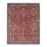 Indian Carpet, circa 1950The claret field with an allover design of flowers and vines enclosed by