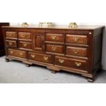 A George III Oak Dresser Base, late 18th century, fitted with an arrangement of drawers around a