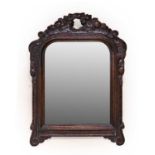 An Early 18th Century Carved Oak Wall Mirror, the later plain mirror plate within a moulded and