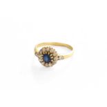 A Sapphire and Diamond Cluster Ring, the round cut sapphire within a border of old cut diamonds,