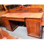 An Early Victorian Twin Pedestal Breakfront Sideboard, the pedement carved with crest and moto ''