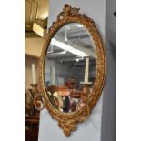 A 19th century Giltwood and Gesso Girandole Wall Mirror, with oval plate and two sconces, 54cm by