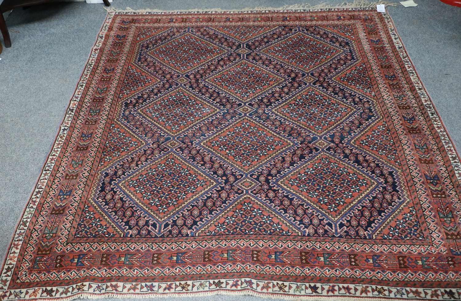 An Afshar Rug, the indigo diamond lattice field of stepped medallions enclosed by narrow madder