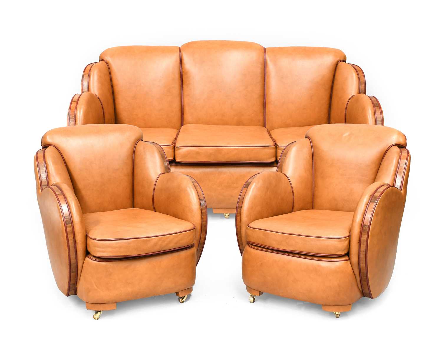 An Art Deco Cloud Three Piece Suite, re-upholstered in tan leather, trimmed in walnut, with cognac