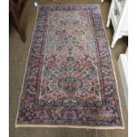 A Pair of Kirman Rugs, each within an ivory field of flowering plants, enclosed by indigo borders,