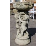 A Weathered Composition Bird Bath, the base moulded with putti, 95cm high