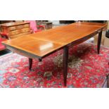 A French Art Deco 6ft Rosewood Dining Table, the shaped rectangular top on four splayed legs,