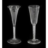 A Pair of Glass Ale Flutes, circa 1745, the drawn trumpet bowls on air twist stems and folded