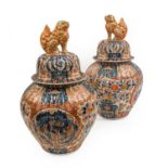 A Pair of Imari Porcelain Jars and Covers, Meiji period, of fluted baluster form with lion dog