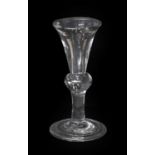 A Deceptive Heavy Baluster Wine Glass, circa 1730, the thistle-shaped bowl with basal air tear, on a