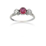 A Ruby and Diamond Three Stone Ringthe round cut ruby flanked by round brilliant cut diamonds, to