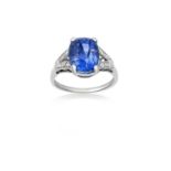 A Sapphire and Diamond Ringthe cushion cut sapphire in a white four claw setting, to eight-cut