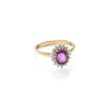 A 9 Carat Gold Ruby and Diamond Cluster Ring, the oval cut ruby within a border of round brilliant