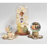 An Early Victorian Figure under a Glass Dome, together with two Victorian snow globes