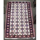 An Unusual Oriental Rug, probably Karabagh, the ivory field with columns of stylised flower heads,