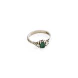 An 18 Carat Gold Emerald and Diamond Three Stone Ring, the oval cut emerald flanked by round