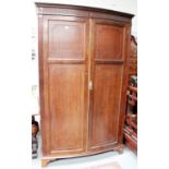 A Mahogany Bow Front Double Wardrobe, by makers Druce & Co, with reeded pilaster supports,