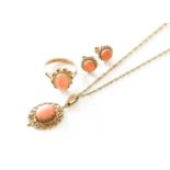 A 9 Carat Gold Coral Pendant on Chain, the oval coral cabochon in yellow claw and filigree