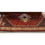 Kashgai Rug, the raspberry field of tribal motifs around a stepped ivory medallion framed by ivory