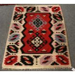 Moldovan Kilim, the crimson field with two hooked medallions enclosed by ivory borders, 163cm by