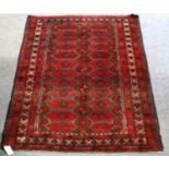 A Red Baluch Rug, the field with two columns of hexagons enclosed by narrow borders, 183cm by 103cm