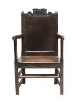 A Late 17th Century Joined Oak English Armchair, the scrolled top rail above moulded finials and a