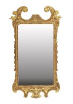 A George II Carved Giltwood Mirror, circa 1740, the plain mercury plate within a carved border,