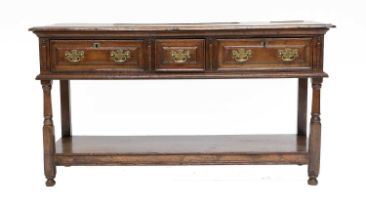 A 17th Century-Style Oak Dresser, the moulded top above three pine-lined drawers with applied