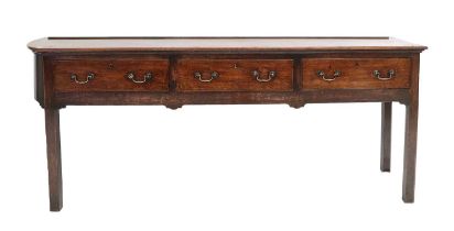 A George III Oak Dresser Base, 3rd quarter 18th century, of unusual form, the boarded top with a