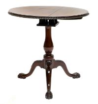 A George III-Style Carved Mahogany Tripod Table, 19th century, the moulded flip top carved with C